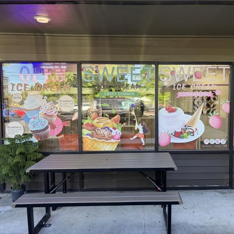 Window decorated with colorful ice cream decals at Crunchy Sweet, a Ice Cream Shop in Portland